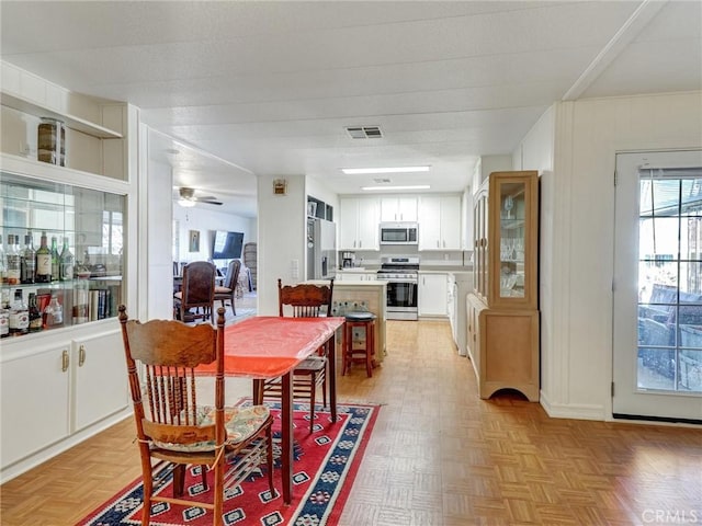 dining area with ceiling fan and visible vents