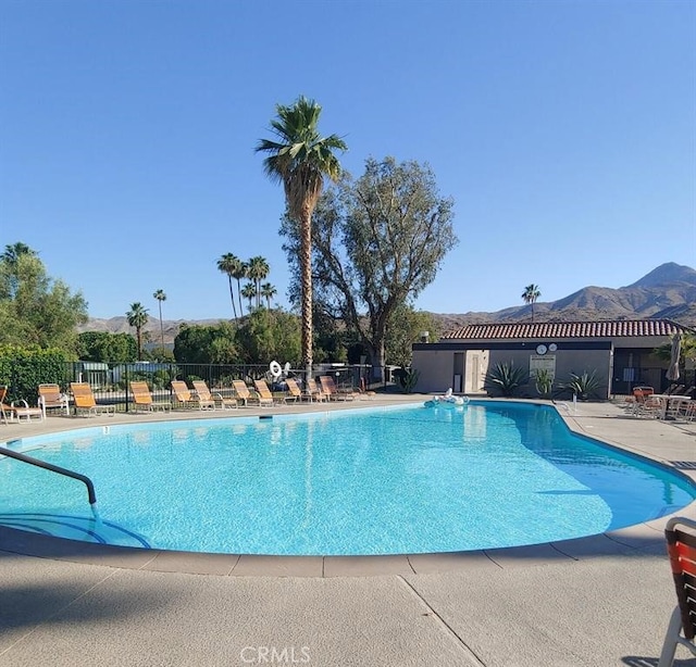 view of swimming pool with a mountain view and a patio area