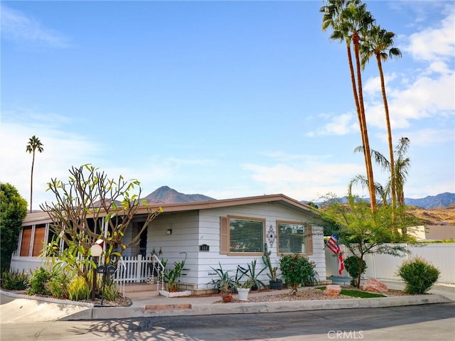 ranch-style house with fence and a mountain view