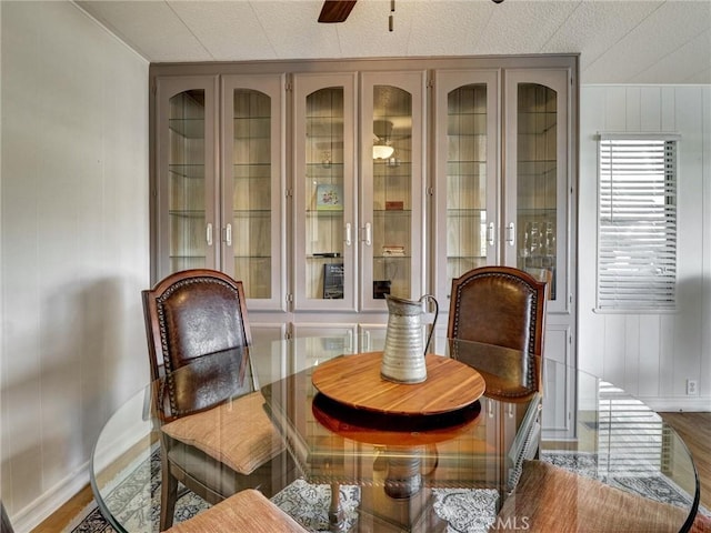 living area with wood finished floors, a ceiling fan, and baseboards