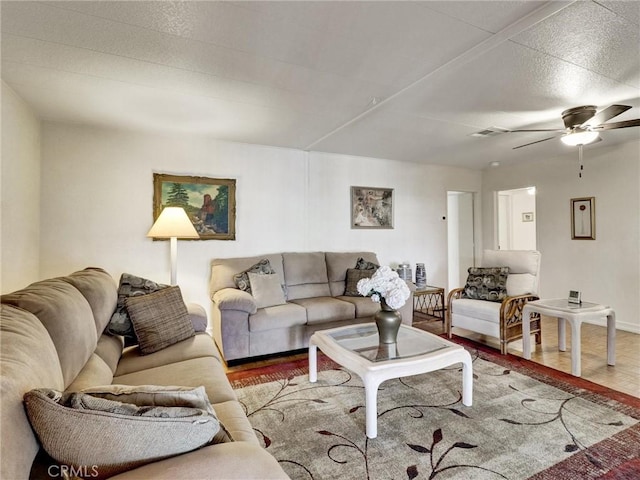 living room featuring a ceiling fan, visible vents, and wood finished floors