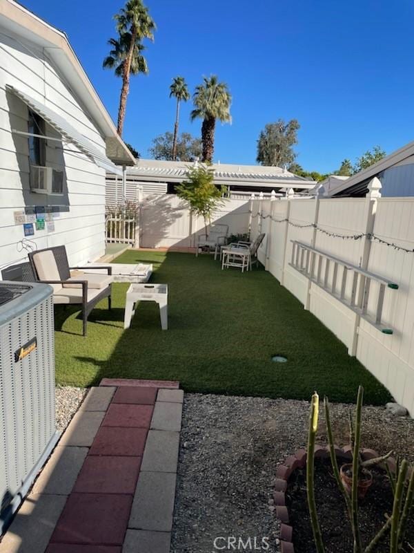 view of yard with a fenced backyard and central air condition unit