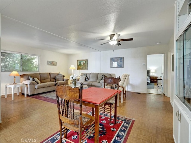 dining room featuring ceiling fan, a textured ceiling, and baseboards