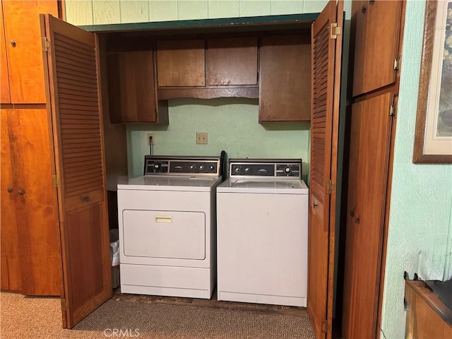 washroom with washing machine and dryer and cabinet space