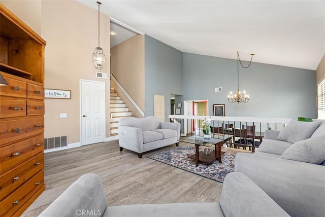 living room featuring high vaulted ceiling, an inviting chandelier, and light hardwood / wood-style floors