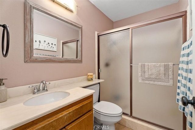 bathroom with vanity, a shower with shower door, tile patterned floors, and toilet