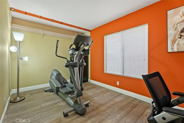 exercise room with light hardwood / wood-style floors