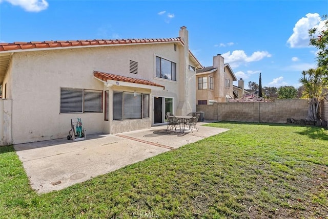 back of property featuring a yard and a patio