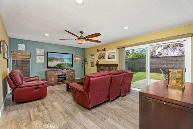 living room featuring ceiling fan and light hardwood / wood-style flooring