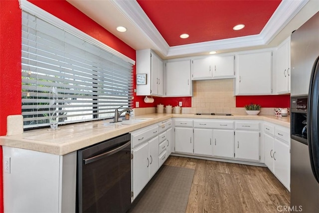 kitchen featuring sink, white cabinetry, ornamental molding, a tray ceiling, and black appliances