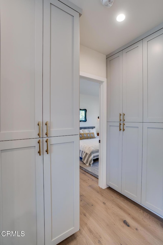 hallway with light hardwood / wood-style floors