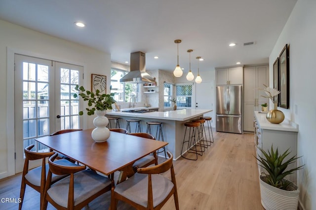 dining space featuring french doors and light hardwood / wood-style flooring