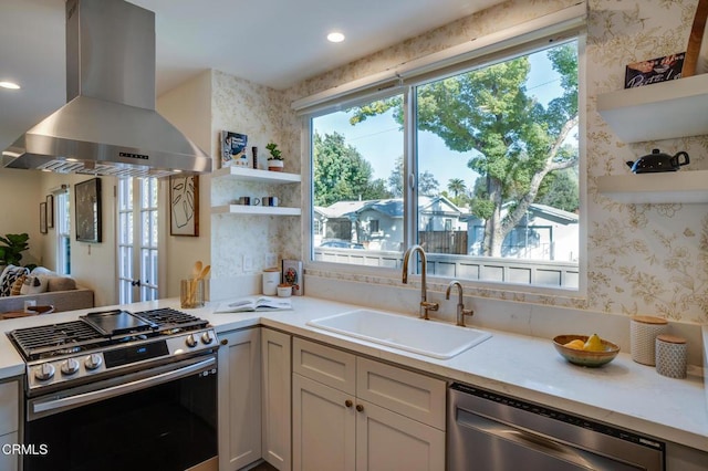 kitchen featuring stainless steel appliances, island exhaust hood, sink, and white cabinets