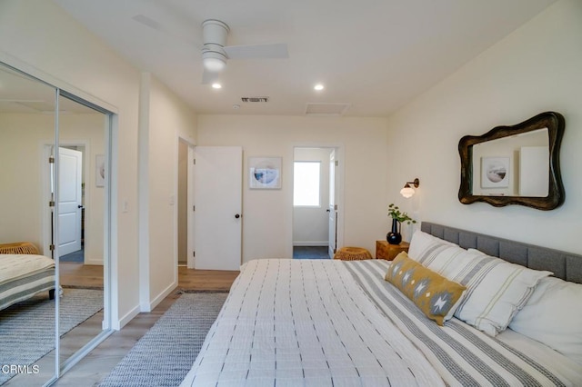 bedroom featuring wood-type flooring, ceiling fan, and a closet