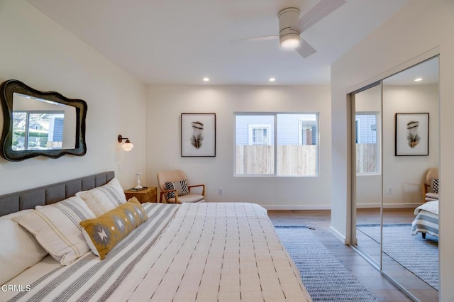 bedroom with multiple windows, ceiling fan, and light hardwood / wood-style floors