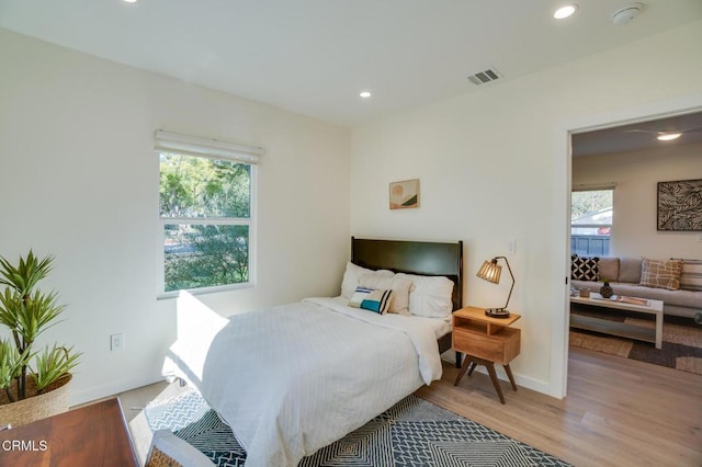 bedroom with multiple windows and light hardwood / wood-style flooring