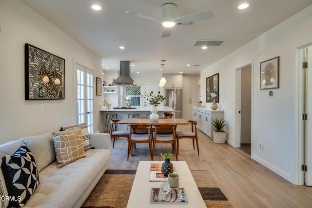 living room featuring ceiling fan and light hardwood / wood-style floors