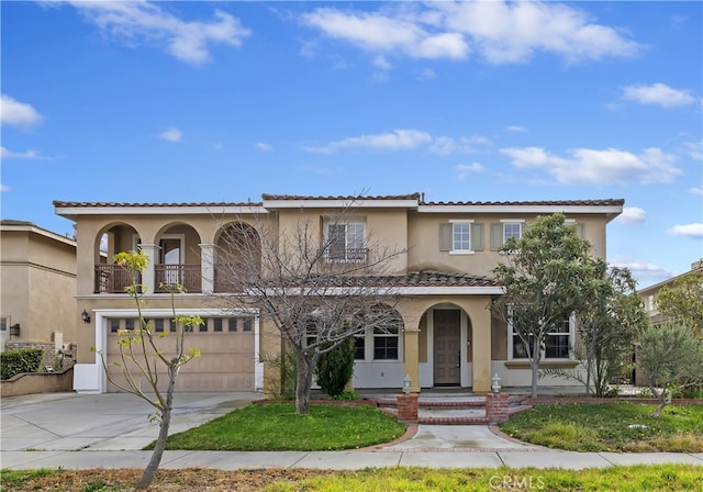 mediterranean / spanish-style home featuring a garage and a balcony