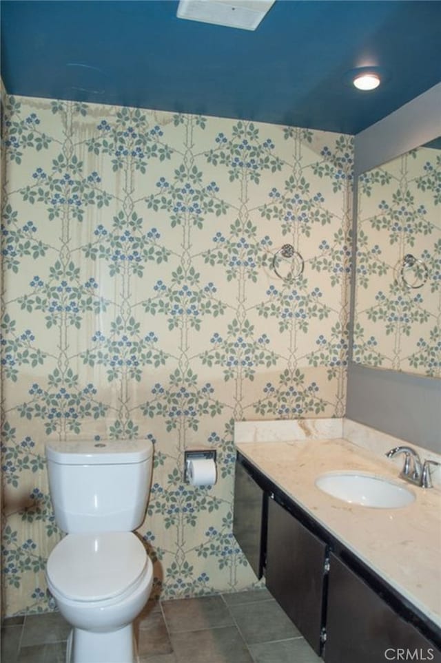 bathroom featuring vanity, tile patterned floors, and toilet