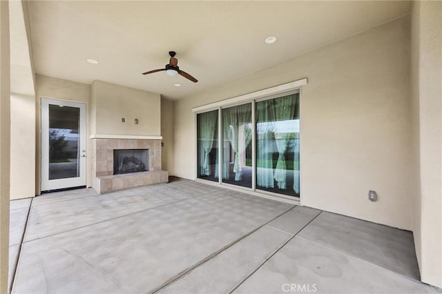 view of patio / terrace with a fireplace and ceiling fan