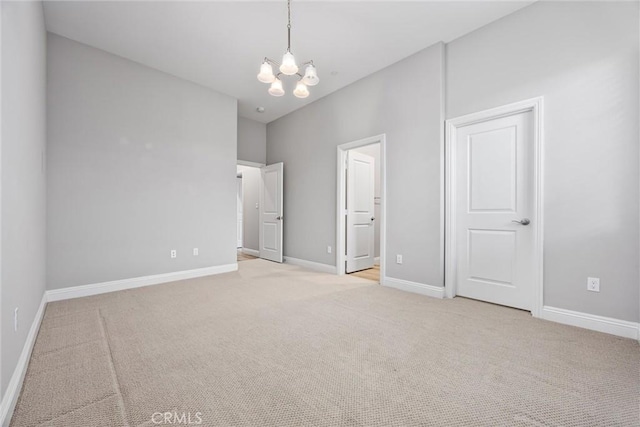 unfurnished bedroom with light carpet and a notable chandelier