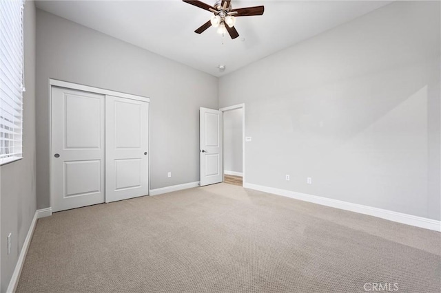 unfurnished bedroom with light colored carpet, ceiling fan, and a closet