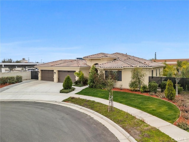 mediterranean / spanish-style home with a garage and a front lawn