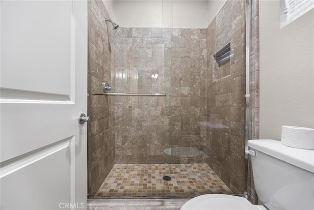 bathroom featuring toilet and tiled shower