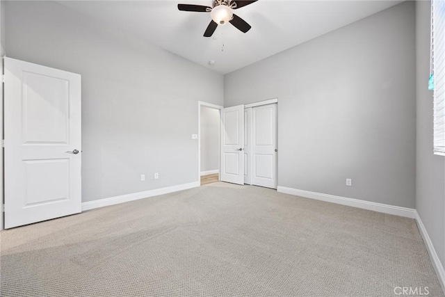 unfurnished bedroom featuring ceiling fan, light colored carpet, and a closet