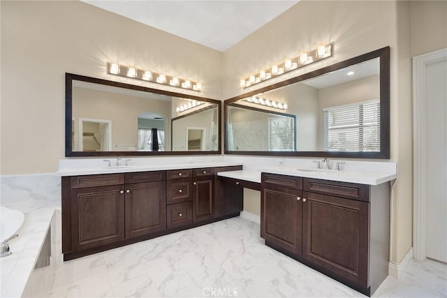 bathroom with vanity and tiled bath