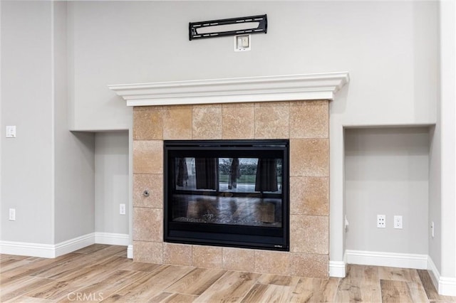 interior details with hardwood / wood-style flooring and a tile fireplace