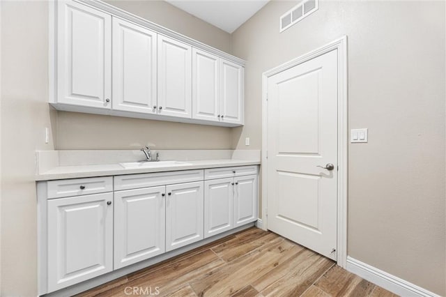 laundry area featuring sink and light wood-type flooring