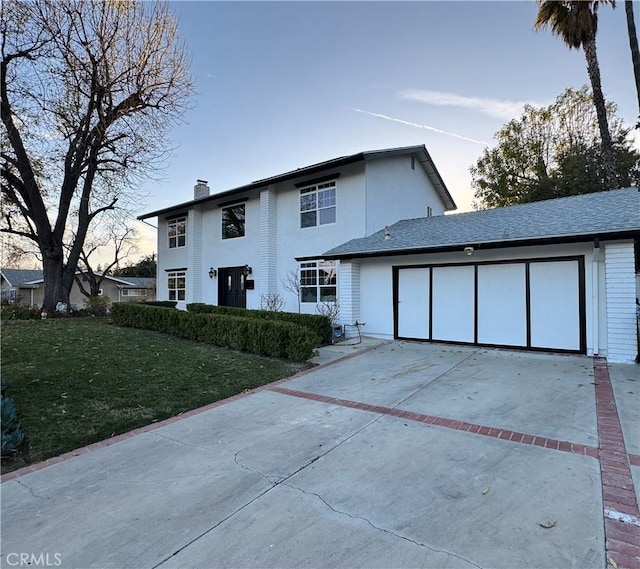 view of front of property featuring a garage and a yard