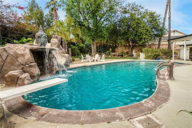 view of pool with pool water feature, a diving board, and a patio