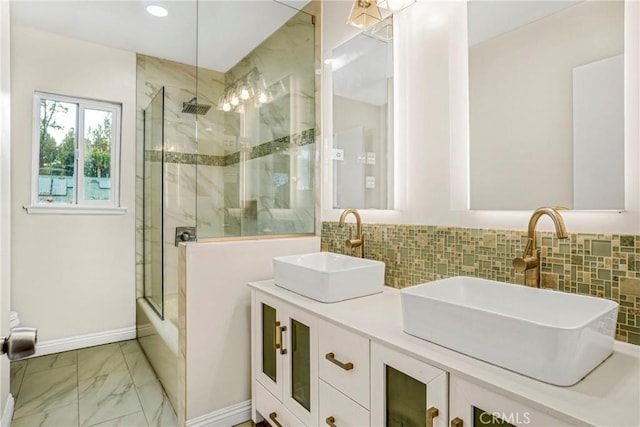 bathroom with vanity, shower / bath combination with glass door, and backsplash