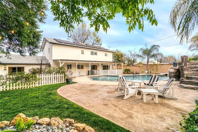 view of pool with pool water feature, a yard, and a patio area