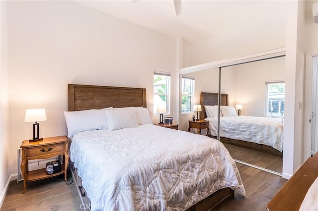 bedroom featuring ceiling fan, a closet, dark hardwood / wood-style flooring, and multiple windows