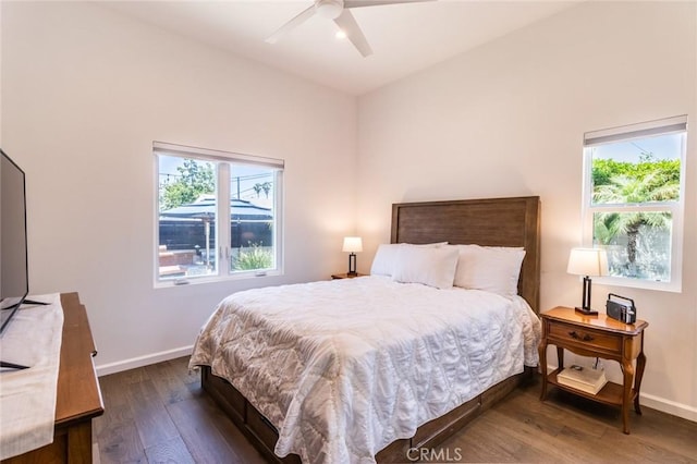 bedroom featuring multiple windows, dark hardwood / wood-style flooring, and ceiling fan