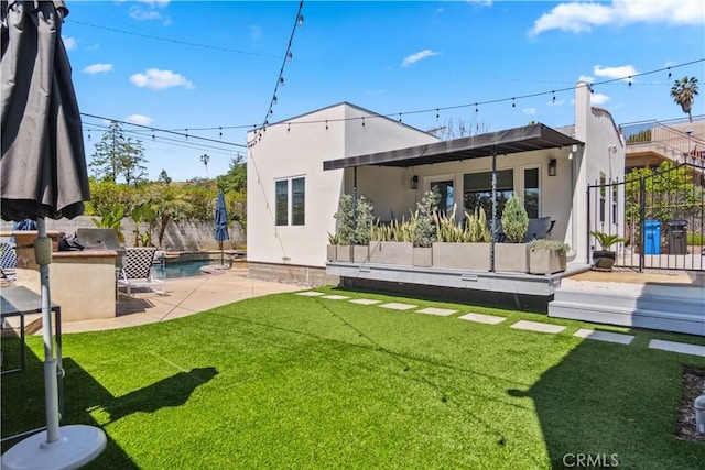 back of property with a fenced in pool, a patio, and a lawn