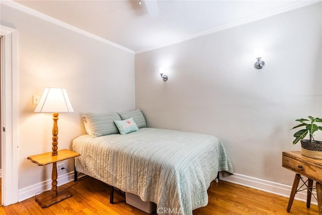 bedroom featuring hardwood / wood-style floors and crown molding