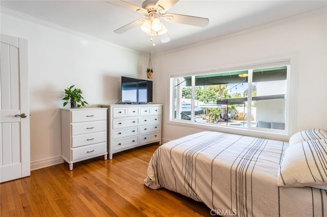 bedroom with ceiling fan, ornamental molding, and light hardwood / wood-style flooring