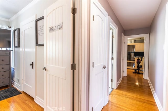 hallway featuring ornamental molding and light hardwood / wood-style flooring