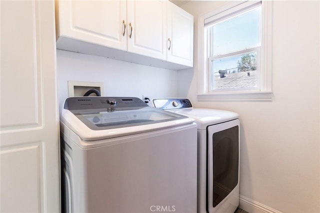 laundry area featuring independent washer and dryer and cabinets