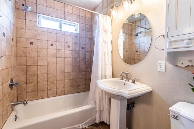 bathroom featuring shower / bathtub combination with curtain and toilet