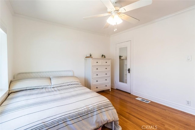 bedroom featuring ceiling fan, ornamental molding, and hardwood / wood-style floors