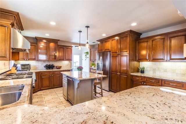 kitchen featuring ventilation hood, appliances with stainless steel finishes, decorative backsplash, and decorative light fixtures