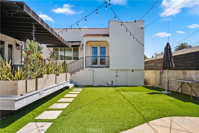 rear view of house featuring french doors and a yard