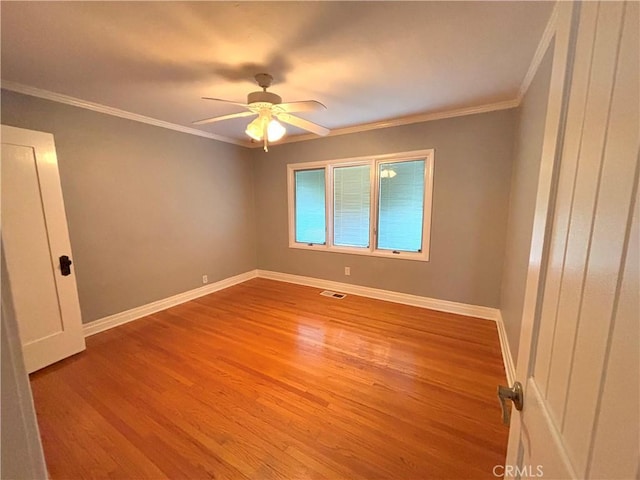 spare room featuring ceiling fan, ornamental molding, and light hardwood / wood-style flooring