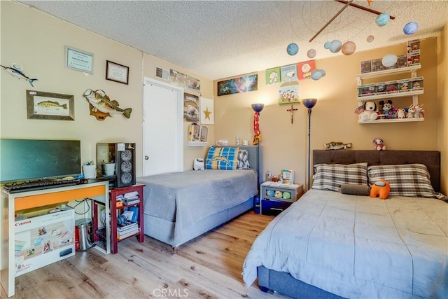 bedroom with wood-type flooring and a textured ceiling