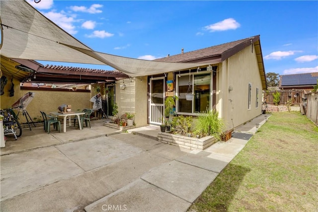 rear view of house with a patio, a pergola, and a lawn